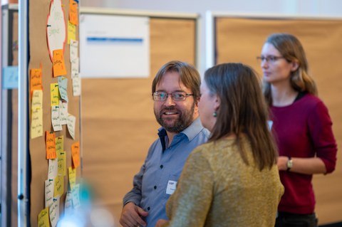 Ansicht Teilnehmende in Austausch an Tafel
