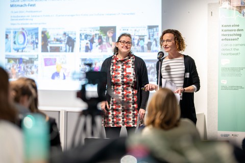 Zwei Referentinnen während ihres Inputvortrages vor Mikrofon und Powerpoint-Präsentation
