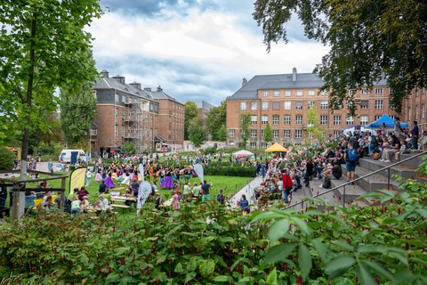 Panoramablick auf den Innenhof des Fritz-Foerster-Baus während des Familienfestes. Zahlreiche Besucher:innen sind zu sehen.