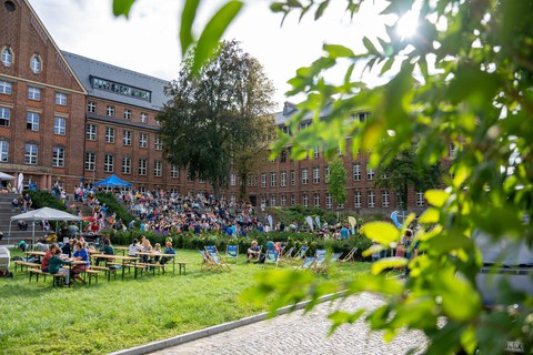 Panoramablick auf den Innenhof des Fritz-Foerster-Baus während des Familienfestes. Zahlreiche Besucher:innen sind zu sehen.
