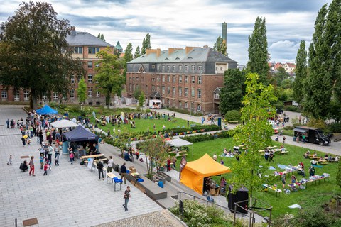 Panoramablick auf den Innenhof des Fritz-Foerster-Baus während des Familienfestes. Zahlreiche Besucher:innen sind zu sehen.