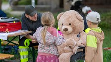 großer Teddy mit Notfallsanitäter und zwei Kindern