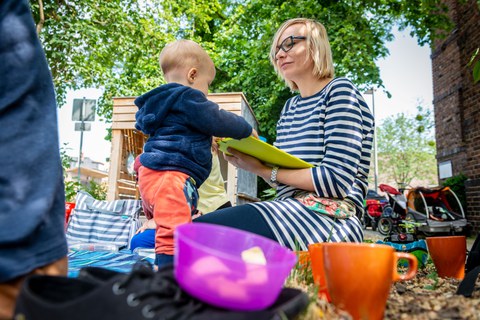 Eltern sitzen mit ihren Kindern auf dem TUD-Spielplatz Campuskiste