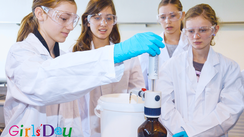 Mehrere Schülerinnen in Laborkitteln und Schutzbrillen arbeiten gemeinsam an einem Experiment im Labor und nutzen dabei ein technisches Gerät; Girls’ Day Logo unten links.