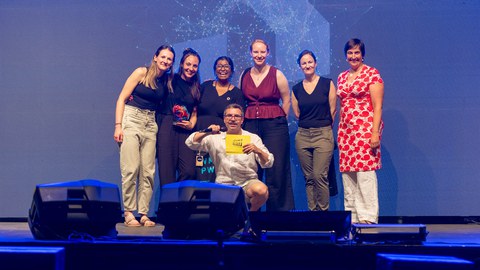 Gruppenbild der fünf Slammerinnen gemeinsam mit Moderator Simon Hauser und Dr. Sylvi Bianchin vom Diversity Management der TUD.