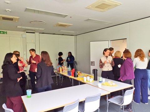 Viele Frauen stehen um Tisch und sprechen miteinander