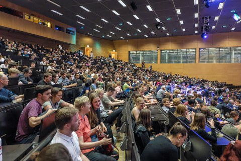 Eine große Anzahl an Menschen in einem Vorlesungsaal