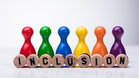 Six colorful game pieces with small wooden stones in front of them, each with a letter printed on it and together forming the word "INCLUSION", all shapes pale reflection on the background surface.