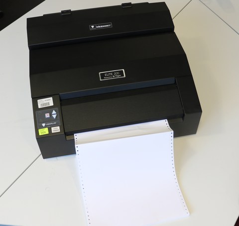 Foto zeigt den Braille Drucker Elite 200 sowie das einziehende Endlospapier