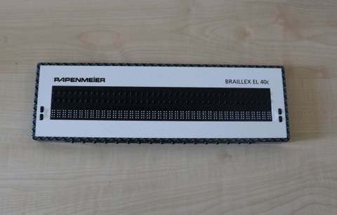 Foto zeigt die Mobile Braillezeile 40 Zellen Braillex EL 40 c der Firma Pappenheimer auf dem Tisch liegend.