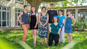 Menschen vor einem Baum posieren gemeinsam als Gruppe für die Kamera