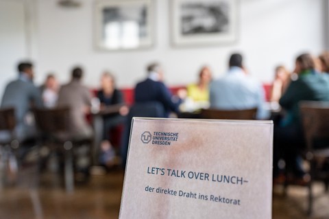 Tischschild mit der Aufschrift "Let´s talk over lunch"