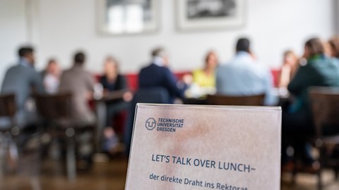 Tischschild mit der Aufschrift "Let´s talk over lunch"