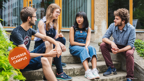 Im Freien sitzen vier ERASMUS Studenten auf einer Treppe und unterhalten sich.