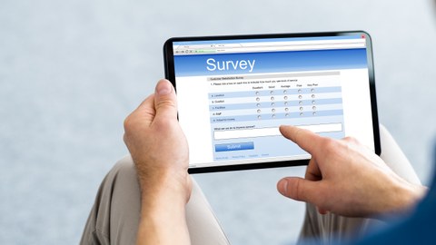 Photo of a person filling out a survey on their tablet
