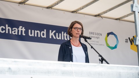 Roswitha Böhm steht auf einer Bühne und spricht.