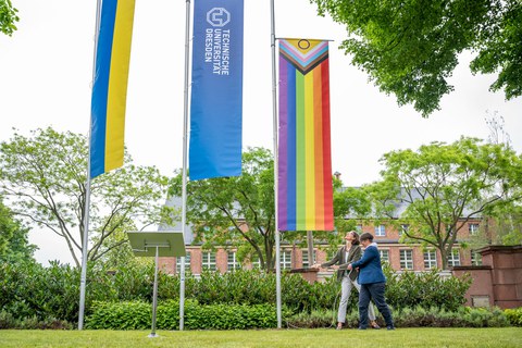 Prorektorin Böhm und Staatssekreträin Dr. Märtens hissen gemeinsam die Progressive Pride Flag