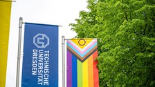 Ausschnitt der Progressive Pride Flag und Flagge der TU Dresden