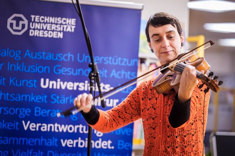 Eine Künstlerin spielt Quintone. Im Hintergrund ist ein Aufsteller der TUD zu sehen.