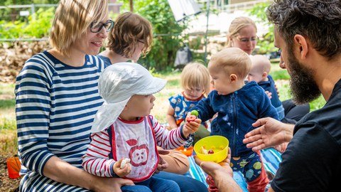 Foto von Eltern mit ihren Kindern auf einer Wiese