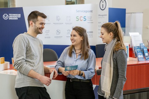 drei Personen unterhalten sich vor dem Service-Center-Studium im Foyer der SLUB