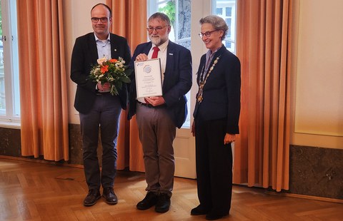 Foto von der Verleihung der TUD-Ehrenmedaille 2026; v.l.n.r. Prof. Dr. Lars Bernard, CDIO der TUD, Prof. Wolfgang E. Nagel mit seiner Urkunde anläßlich der Verleihung der Ehremedaille an ihn, Frau Prof. Dr. Ursula Staudinger, Rektorin der TUD