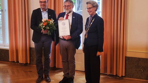 Foto von der Verleihung der TUD-Ehrenmedaille 2026; v.l.n.r. Prof. Dr. Lars Bernard, CDIO der TUD, Prof. Wolfgang E. Nagel mit seiner Urkunde anläßlich der Verleihung der Ehremedaille an ihn, Frau Prof. Dr. Ursula Staudinger, Rektorin der TUD