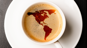 Das Foto zeigt eine Tasse Espresso. Der Schaum des Espressos bildet die Umrisse einer Weltkarte.