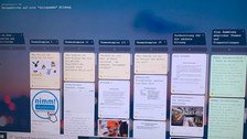 Das Foto zeigt einen Computerbildschirm mit dem Programm "Padlet" offen. Links oben steht die Überschrift "Perspektiven auf eine zeitgemäße" Bildung". Der Bildschirm ist in 6 Spalten unterteilt, jede Spalte hat eine Überschrift, darunter sind in Rechtecken Beiträge zu sehen. Im Hintergrund des Padlets ist ein verschwommenes Bild in Blautönen zu sehen.