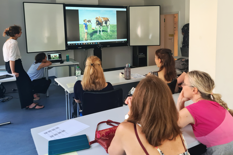 Klassenzimmer mit Reihen von Studierenden vor einem Bildschirm
