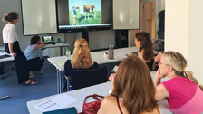 Klassenzimmer mit Reihen von Studierenden vor einem Bildschirm