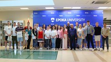 Ca. 25 Menschen, die vor einer blauen Wand stehen, auf der EPOKA UNIVERSITY steht