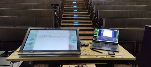 Aufbau Aufnahme, Dozentenpult im Hörsaal mit Laptop, Tablet und Kamera