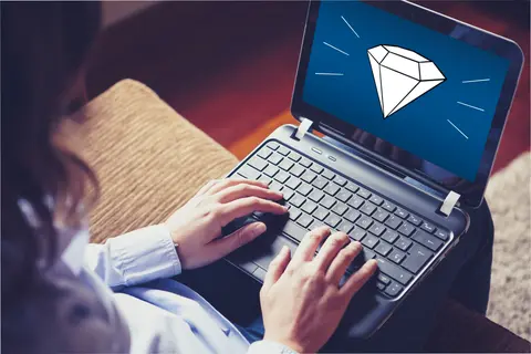 Frau mit Laptop auf dem Schoß, auf dem Display das Schmuckstück-Logo - ein Diamant
