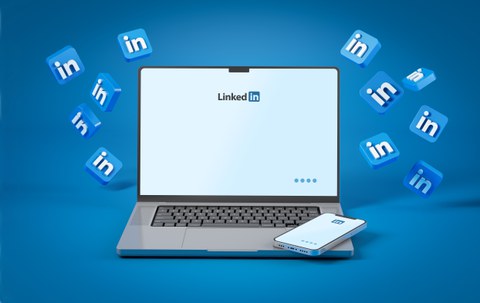 Ein Laptop mit einem Smartphone daneben, beide mit dem LinkedIn-Logo auf dem Bildschirm. Um das Gerät herum schweben mehrere blaue LinkedIn-Symbole auf einem blauen Hintergrund.