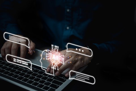 Hands typing on a laptop keyboard with glowing digital icons above it, including an AI chip inside a head outline and several floating chat bubbles.