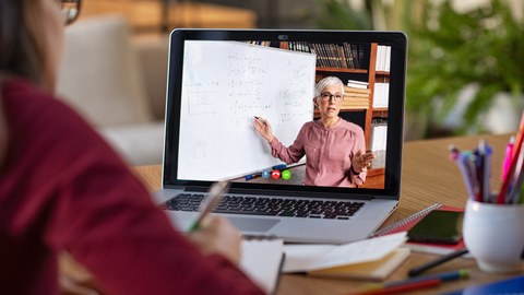 Das Foto zeigt eine Videokonferenz mit einer Frau auf dem Bildschirm