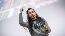 Gustavo Rosales präsentiert seinen Science Slam. In der hand hält er eine grüne Paprika.
