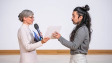 Henriette Greulich überreicht Gustavo Rosales eine Urkunde