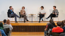 Auf der Bühne sitzen die vier Teilnehmenden des Podiumsgesprächs.