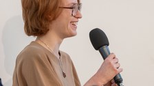 Eine Frau spricht in ein Mikrofon.