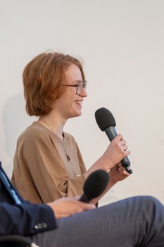 Eine Frau spricht in ein Mikrofon.