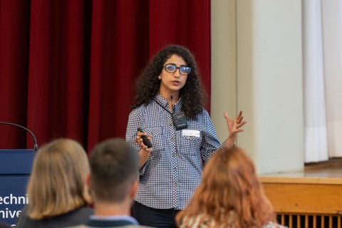 Eine Studentin hält vor Publikum einen Vortrag.
