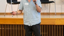 Ein Student steht vorne und spricht in ein Mikrofon.