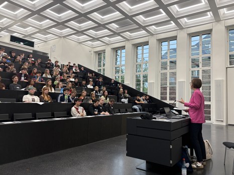 The vize rector speaks to a large group of students in a bright lecture hall.