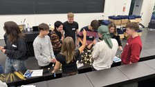 Studierende arbeiten in Gruppen an einem Bauprojekt aus Spaghetti und Marshmallows in einem Hörsaal.