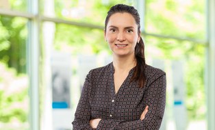 Portraitfoto Melanie Ludwig im Hörsaalzentrum der TU Dresden vor einer Glaswand mit Blick in den grünen Innenhof.