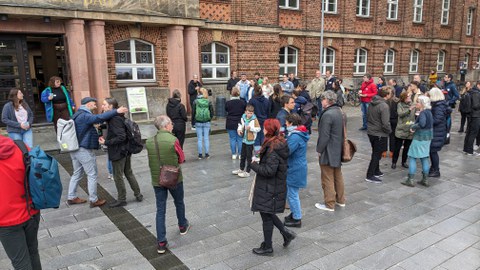 Viele Menschen stehen auf einem Platz.