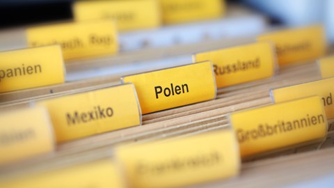 Foto von Akten, die mit Ländernamen wie "Polen", "Russland", "Mexico", etc. beschriftet sind