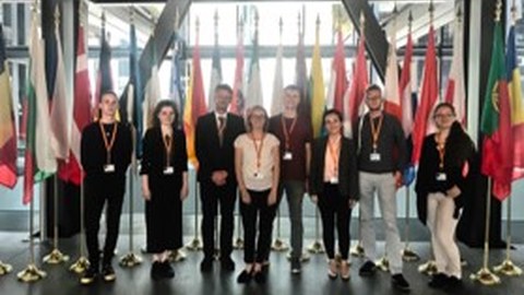 Foto einiger IB-Studierenden vor den Flaggen der EU-Mitgliedsstaaten beim Europäischen Gerichtshof